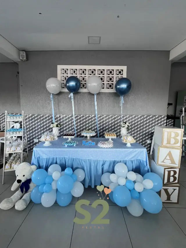 Decoração moderna de chá de bebê em azul e branco, com mesa de doces, balões e cubos BABY