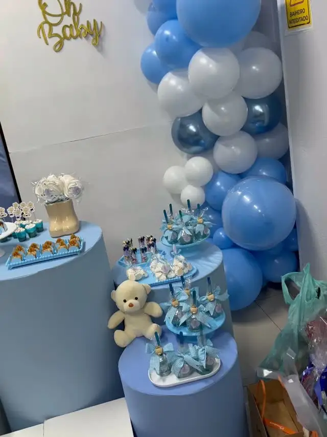 Chá de bebê com arco de balões azuis e brancos e cilindros azuis
