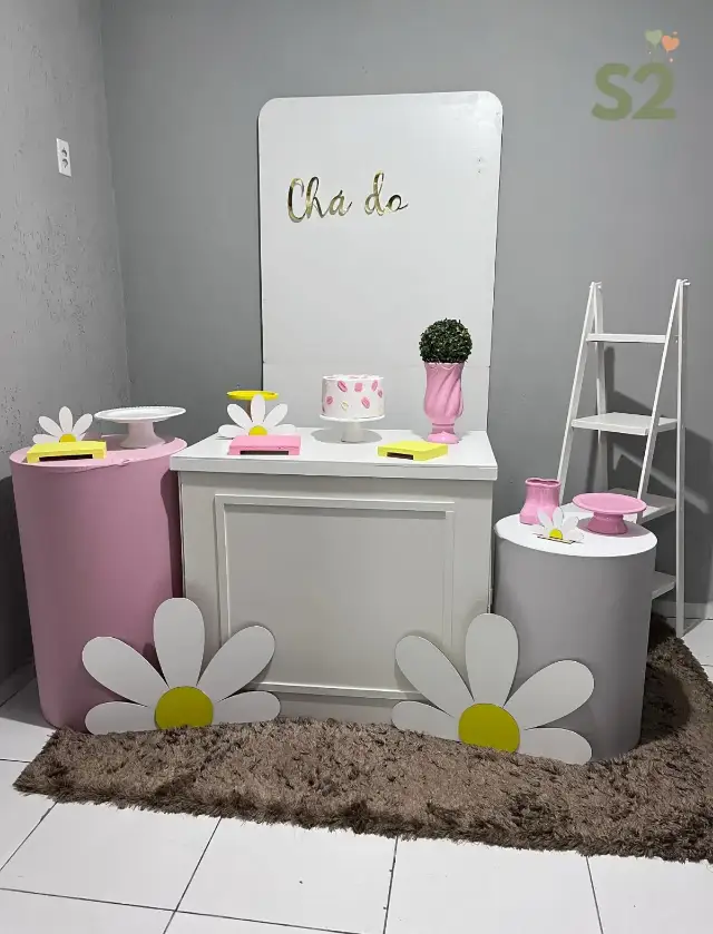 Decoração de chá com margaridas, painel branco e cilindros rosa