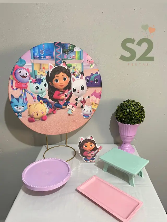 Festa na Mesa com painel redondo da Casa Mágica da Gabby e bandejas lilás, rosa e verde