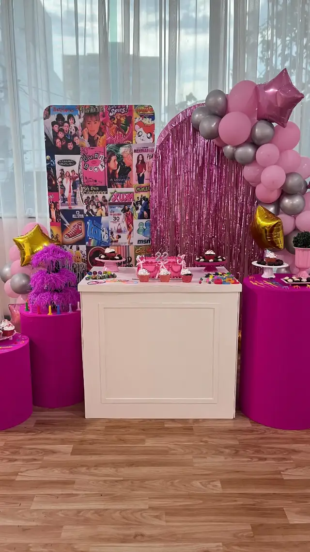 Decoração anos 2000 em tons de rosa, com balões, cortina metalizada e cilindros
